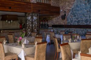 a restaurant with tables and chairs and a brick wall at Kruger Park Lodge Unit No. 221 in Hazyview