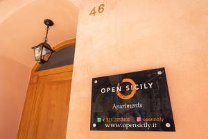 a sign on the side of a door with a lamp at Open Sicily Quattro Canti Apartments in Palermo
