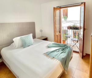 Un dormitorio con una gran cama blanca y un balcón. en Casa Elizabeth, en Altea
