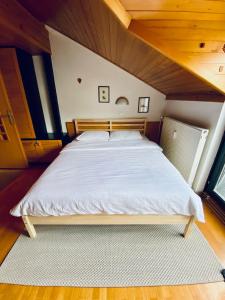 a large bed in a room with a wooden ceiling at Apartma Snežinka in Kranjska Gora