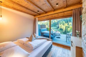 a bedroom with a bed and a large window at Hotel Alcialc in La Valle