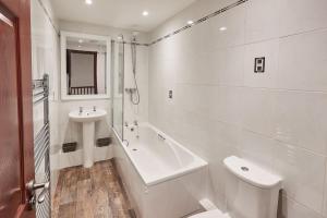 斯卡布羅的住宿－Host & Stay - The Fox，白色的浴室设有水槽、浴缸和卫生间。