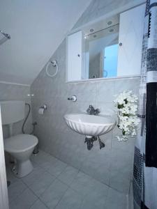 uma casa de banho com um lavatório e um WC em VILLA BLANCA em Charaki