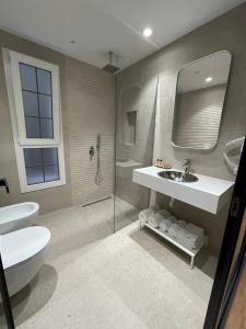 a bathroom with a sink and a toilet and a mirror at Hotel Europa in Tirana