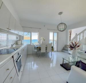 a kitchen and dining room with a view of the ocean at VILLA BLANCA in Haraki