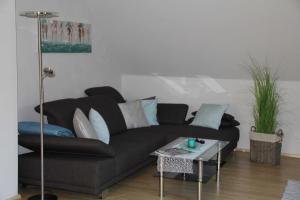 a living room with a black couch and a table at Ferienwohnung am Rosengarten in Ebermannstadt