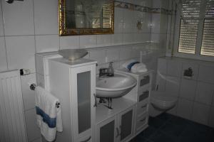 a white bathroom with a sink and a toilet at Ferienwohnung am Rosengarten in Ebermannstadt