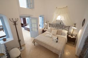 a bedroom with a large bed with white sheets and pillows at Lithies Traditional Homes in Firostefani +70 photos