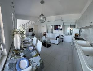 uma cozinha e sala de estar com uma mesa e um sofá em VILLA BLANCA em Charaki