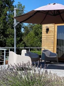 un groupe de chaises assises sous un parasol dans l'établissement "Chez Mima" - à deux pas de Durbuy!, à Durbuy