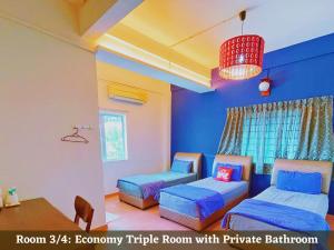 een kamer met 2 bedden, een tafel en een kroonluchter bij KSK Kasih Sayang Kluang Hometel in Kluang