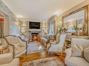 a living room with white furniture and a fireplace at Willington Lodge in Hanmer