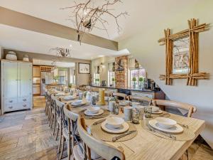 uma grande sala de jantar com uma mesa longa e cadeiras em Willington Lodge em Hanmer