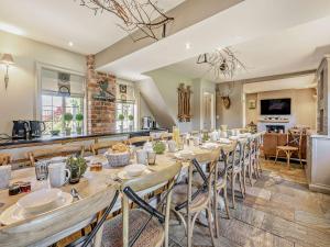 uma grande sala de jantar com uma mesa longa e cadeiras em Willington Lodge em Hanmer