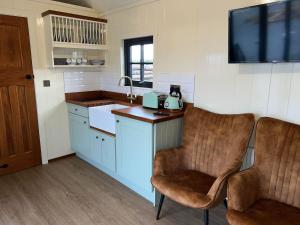 a kitchen with two chairs and a tv on the wall at Slieve Gullion Getaways in Meigh