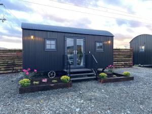 a black tiny house with some flowers and plants at Slieve Gullion Getaways in Meigh