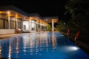 a swimming pool in front of a house at night at Bella House in Hue