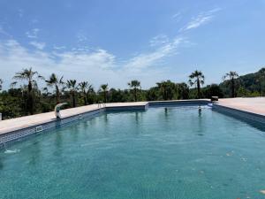 a large swimming pool with palm trees in the background at Hirkan Park Hotel in Lankaran