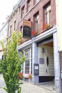 a building with a sign on the side of a street at Hotel O Mal Aime in Stavelot