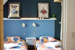 maison bretonne,gîte de keranglaz في Ploubezre: سريرين في غرفة نوم بجدران زرقاء