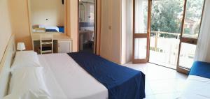 een slaapkamer met een bed en een groot raam bij Hotel Elizabeth in Marina di Pietrasanta