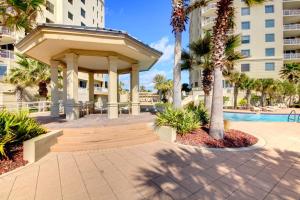 a pavilion in a courtyard with palm trees and a building at Indigo West #2004 in Perdido Key