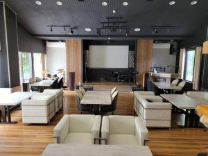 a restaurant with white chairs and tables and a screen at Villa 33 Kashikojima in Ugata