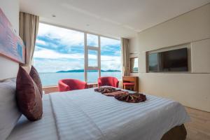 a bedroom with a large bed and a large window at Nha Trang Wonderland Hotel in Nha Trang