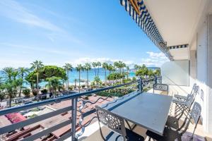 a balcony with a table and chairs and the ocean at Croisette - 2 Chambres - Vue Epoustouflante in Cannes