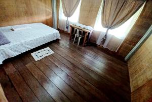 um quarto com uma cama e piso em madeira em Batad Countryside em Banaue