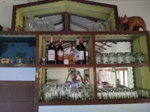 Bhurkīā的住宿－Jungle Heaven Hotel and Cottage，把镜子的照片和瓶子相照的人