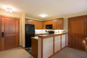 a kitchen with wooden cabinets and a black refrigerator at 2211 - Two Bedroom Standard Eagle Springs East condo in Solitude