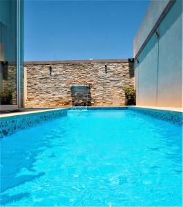 a swimming pool with blue water in a building at St. Peter's Pool Holiday Apartment in Marsaxlokk