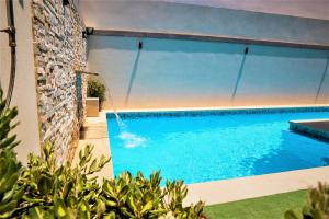 een zwembad in een huis met een muur bij St. Peter's Pool Holiday Apartment in Marsaxlokk