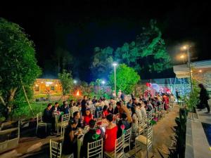 a large crowd of people sitting in chairs at night at Bella House in Hue