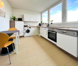 a kitchen with white appliances and a table and chairs at Modernes Apartment mit Stil in City Lage in Karlsruhe