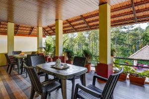 a dining room with tables and chairs and a balcony at Coorg Bliss Estate Stay in Madikeri