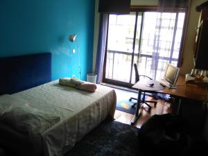 1 dormitorio con cama, escritorio y ventana en Quarto junto ao mar, en Matosinhos