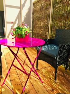 a pink table with a potted plant on a patio at Ferienwohnung Schönwälder in Buxtehude