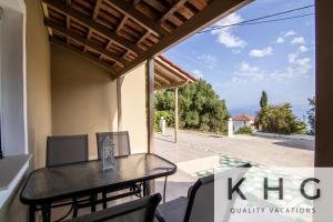 a table on a balcony with a view of the ocean at Irene apartment in Vlachata village! in Kefallonia