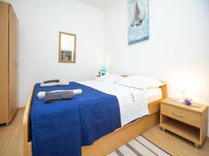 ein Schlafzimmer mit einem Bett mit einer blauen Decke in der Unterkunft Apartment Brunac in Brbinj