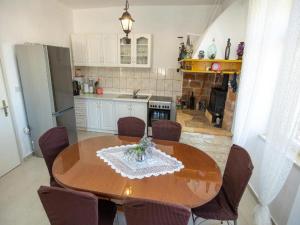 uma cozinha com uma mesa de jantar em madeira e cadeiras em Apartment Brunac em Brbinj