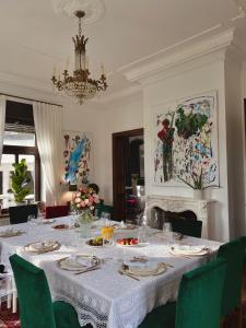 a dining room with a white table with green chairs at Villa Pomona in Bled