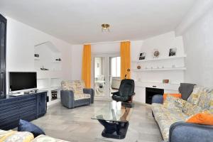 uma sala de estar com um sofá e uma televisão em First Beachline, Malaga em Benalmádena
