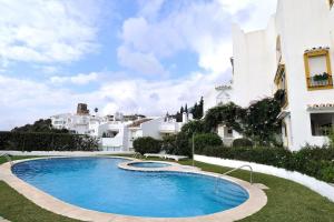 uma piscina em frente a um edifício branco em First Beachline, Malaga em Benalmádena