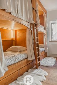 a bedroom with two bunk beds with a ladder at R'Apparts Le Petit Chalet du Téléphérique in Grenoble
