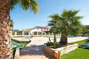 een resort met palmbomen en een zwembad bij Casa Miguelin 2 in Zahora