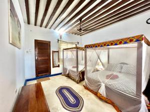 1 dormitorio con 1 cama con dosel en Chikachika Beach B&B en Nungwi