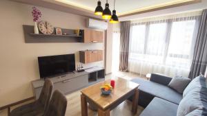 a living room with a blue couch and a table at Апартамент Relax in Smolyan