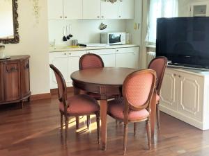 cocina con mesa y sillas y TV en Suite Romantic vista Lago, en Stresa